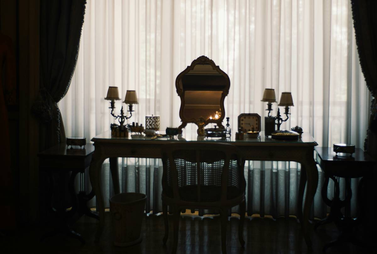 Opulent Choices: woman applying high-end makeup with luxury brushes and product display